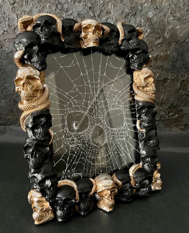 Seitlich fotografierter schwarz-goldener Design-Fotorahmen mit zahlreichen Skull- und Schlangendetails
