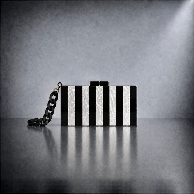 DARK FLOW Pearl Stripe Acryl Clutch in Schwarz-Weiß mit Perlmutt-Effekt, klaren Streifen und schwarzem Gliederarmband in Einzeldarstellung